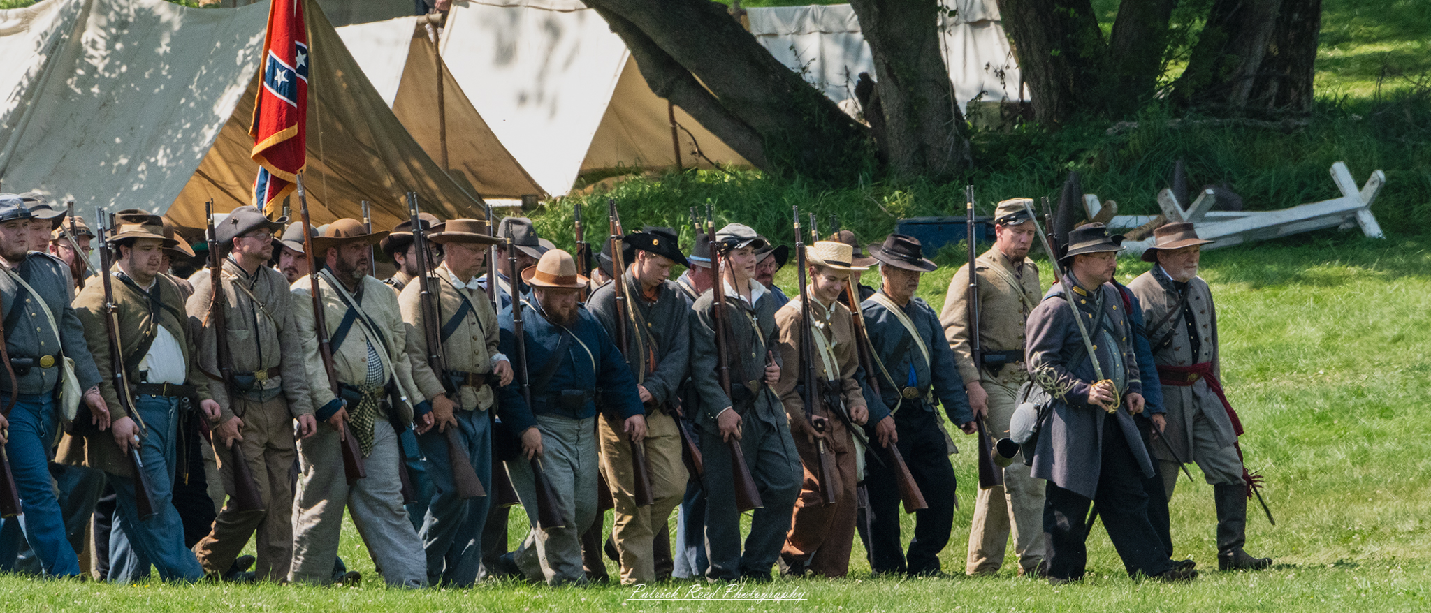 Confederate soldiers marching into battle, dressed in gray uniforms and carrying their rifles at the ready. Their expressions are resolute and determined, reflecting the seriousness of the moment as they move in unison towards the front lines, embodying the courage and commitment of their cause.